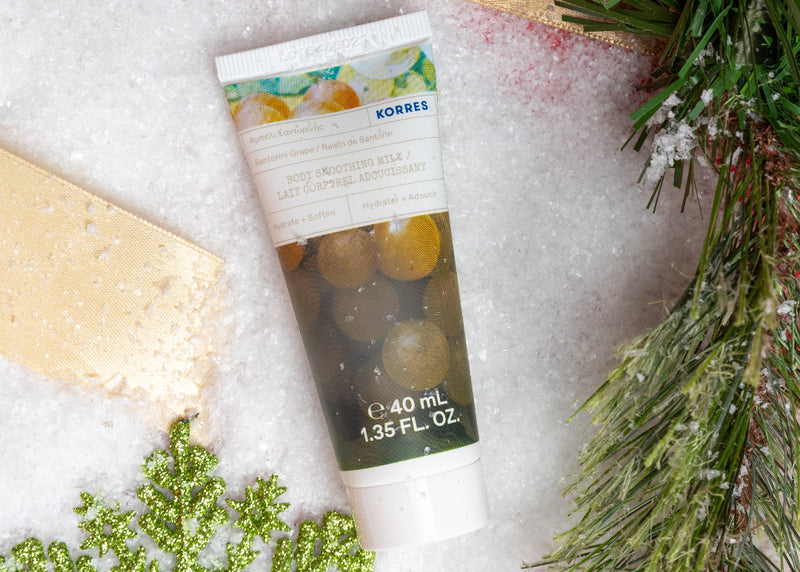 Korres product tube with greenery and snowflake decoration on a textured surface