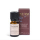 NEOM Wellbeing London Sparkling Joy Essential Oil Blend in a 10 mL amber glass bottle with a black cap, shown next to its dark burgundy box on a white background.