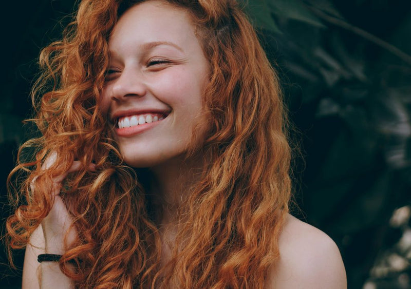 Smily lady with red, long, curly hair