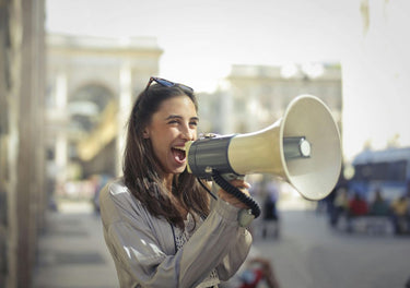 Excited lady shouting through a megaphone