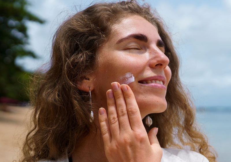 Lady applying sunscreen to her face