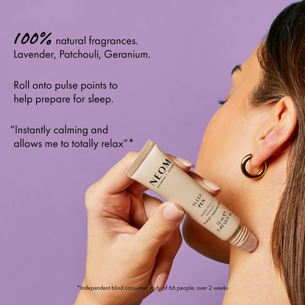 Person applying NEOM sleep balm to their neck with a purple background