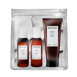 Sachajuan hair care set in a clear zippered pouch, featuring a brown hair retainer treatment tube and two brown bottles with white caps, shown on a white background.