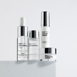 Set of skincare products including a serum, essence, and cream on a white background