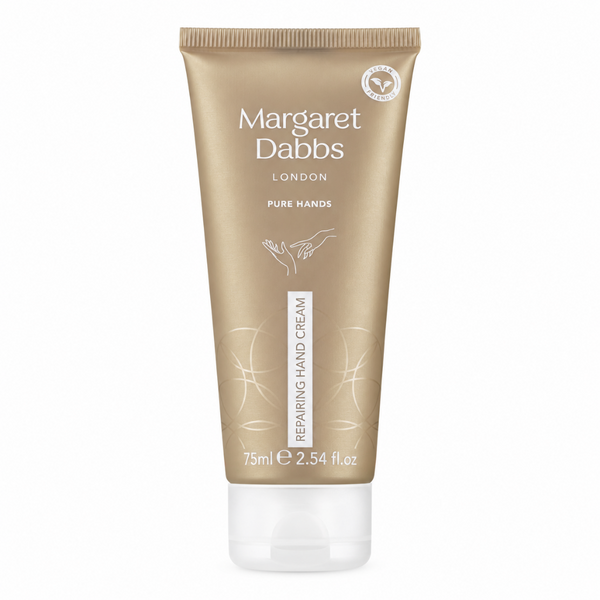 A squeeze tube of Margaret Dabbs London Pure Hands Repairing Hand Cream in a metallic gold color with a clear cap, shown on a white background.