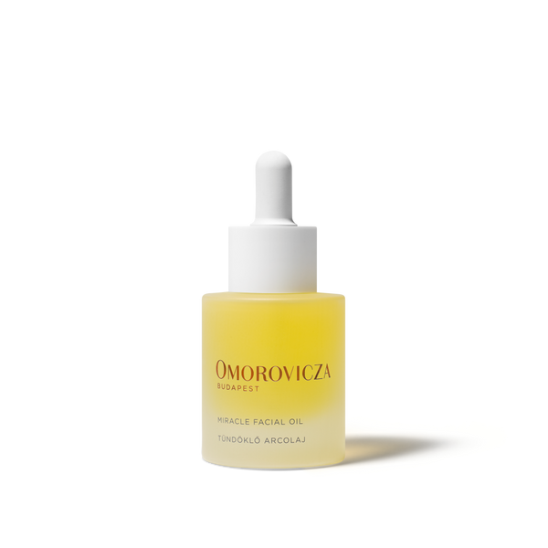 A bottle of Omorovicza Miracle Facial Oil with a white dropper cap, containing a pale yellow liquid, set against a clean white background.