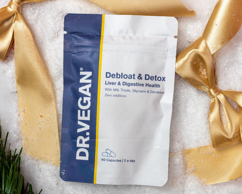 DRVEGAN pet supplement package with gold ribbons and a pine branch on a white background