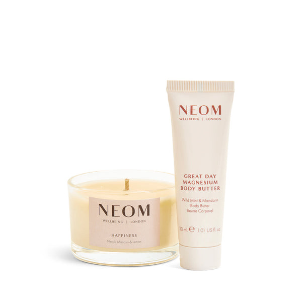 A NEOM Wellness candle and a tube of Great Day Magnesium Body Butter on a clean white background.