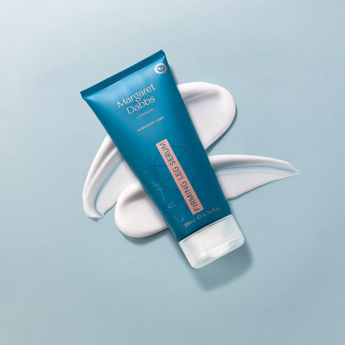 Blue tube of Margaret Dabbs Firming Leg Serum on a light blue background