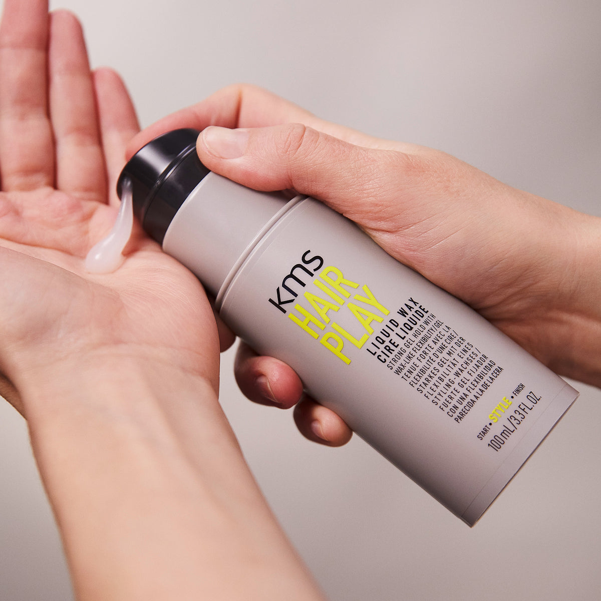 KMS Hair Play product being applied to a hand with a neutral background