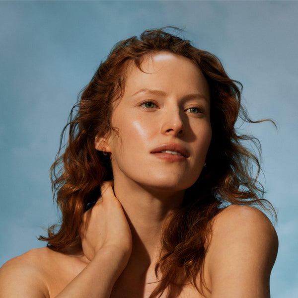 Woman with sun-kissed skin against a blue sky