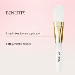 A white and gold makeup brush shown on a soft pink gradient background with text highlighting benefits: 'Streak-free & even application' and 'Soft synthetic bristles.' The brush has the brand name MZ SKIN printed vertically on the handle.