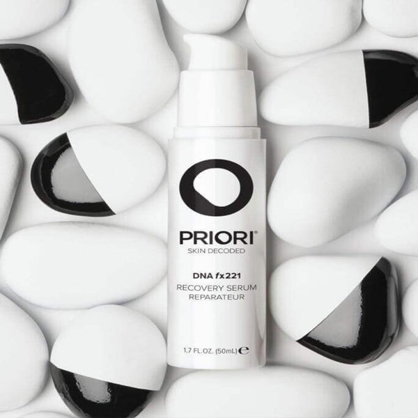 PRIORI DNA - Recovery Serum amongst a range of white and black stones