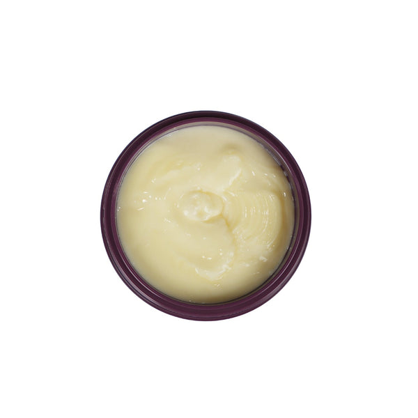 A top-down view of a round jar filled with a pale yellow cream or balm, set against a plain white background.