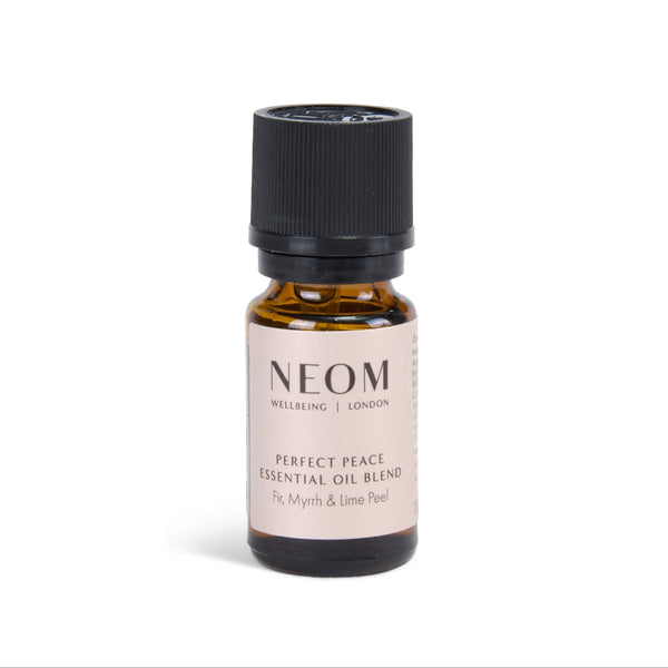 A small amber glass bottle of NEOM Wellbeing London 'Perfect Peace' essential oil blend with a black ribbed cap and a beige label, centered on a white background.