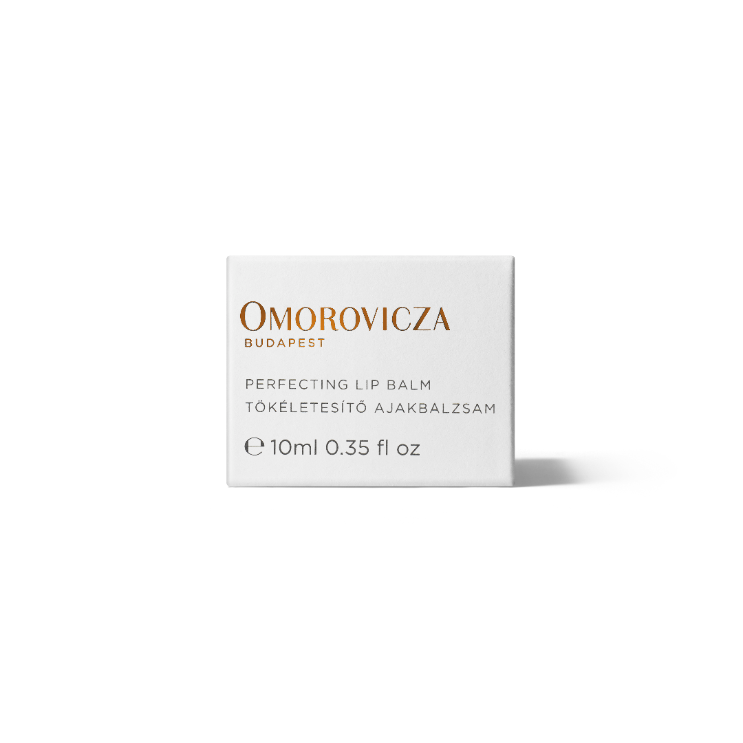 A white rectangular box of Omorovicza Perfecting Lip Balm, featuring gold and black text on a clean white background with a soft shadow.
