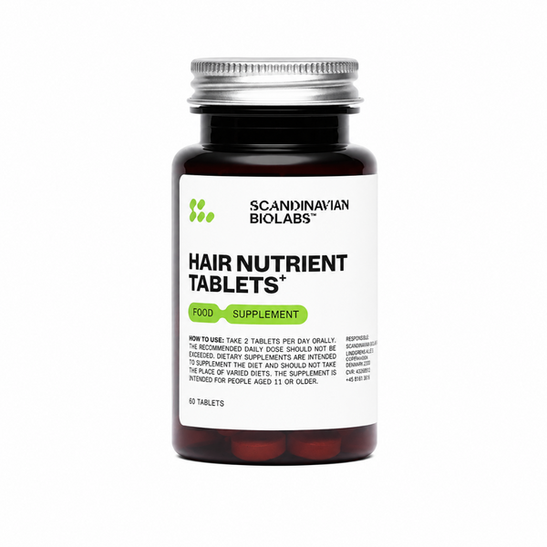 A bottle of Scandinavian Biolabs Hair Nutrient Tablets on a plain white background. The product consists of a dark amber glass bottle with a silver metal cap and a white label featuring black text and green accents.