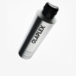 A silver aluminum can of OLAPLEX Shape Set Hair Spray with a black cap, shown floating against a solid white background.