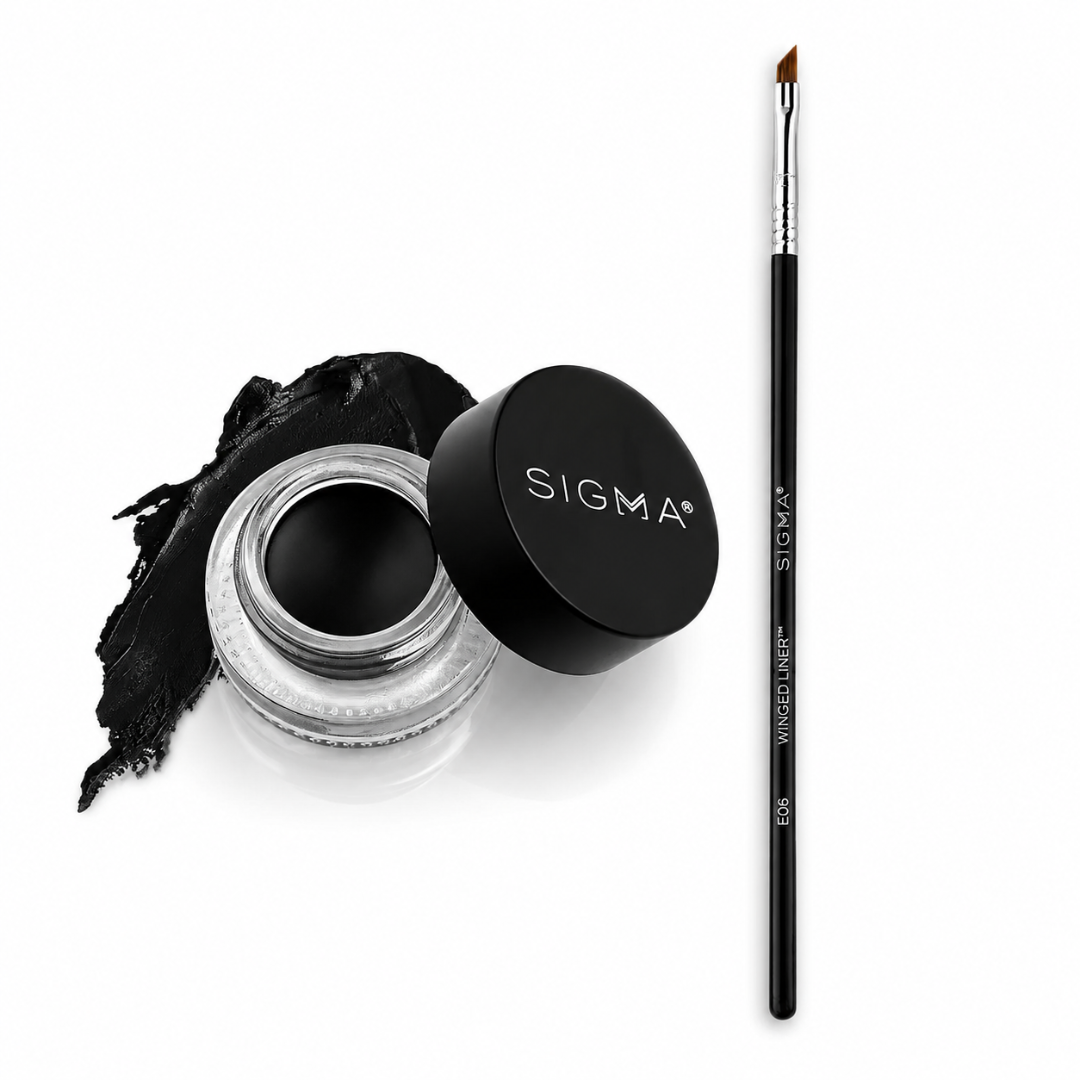 Sigma black gel eyeliner shown in an open clear jar with the black lid beside it, next to a swipe of the black pigment and a fine detail brush on a white background.