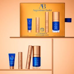 Augustinus Bader skincare products on a peach background