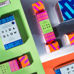 Vida Glow product packaging on a colorful background