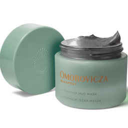 A jar of Omorovicza Budapest Ultra-Hydro Mud Mask with its lid off, showing the gray mask cream inside, on a white background.