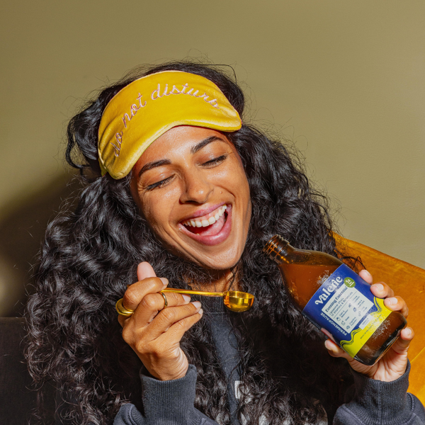 Person wearing a yellow visor and eating from a jar of Valley Farms dressing.