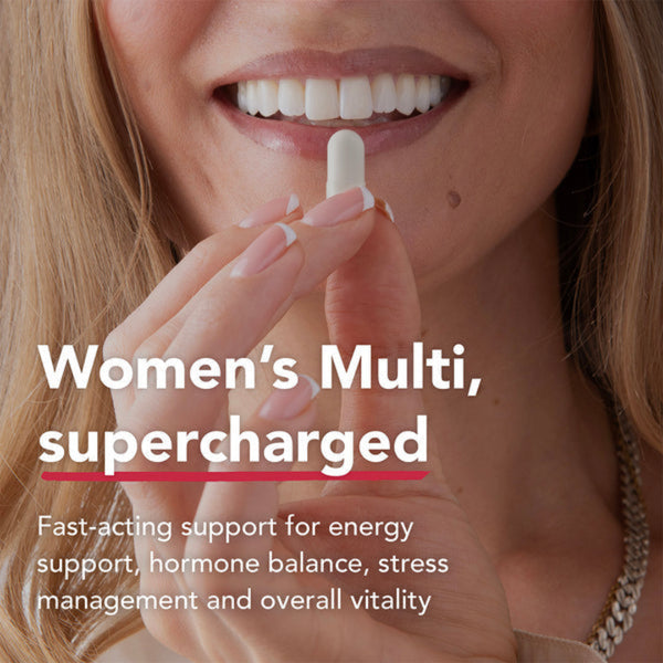 Close-up of a smiling woman holding a white capsule pill near her mouth, with text reading 'Women's Multi, supercharged' and additional product copy about energy, hormone balance, stress management, and overall vitality.