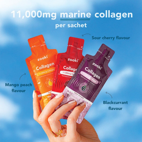 Three zooki collagen sachets in different flavors held by a hand against a blue sky background.