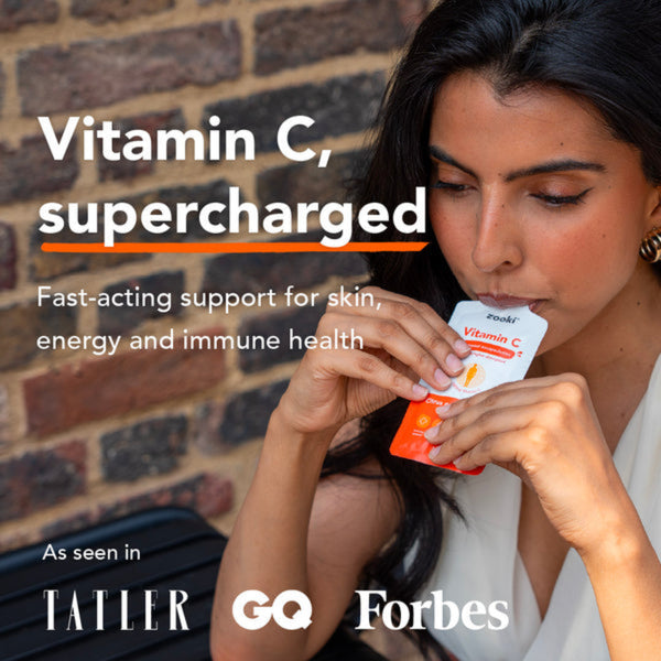 Woman holding vitamin C supplements with text about health benefits and media mentions.