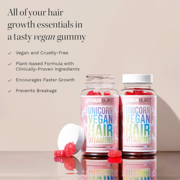 Two bottles of Hairburst Unicorn Vegan Hair Vitamins with red gummy vitamins displayed on a reflective surface against a beige background with promotional text.