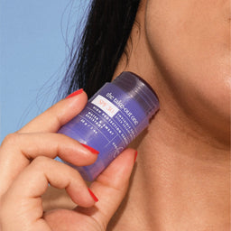 a women applying Hello Sunday The Take Out One Sun Stick SPF30 to her neck